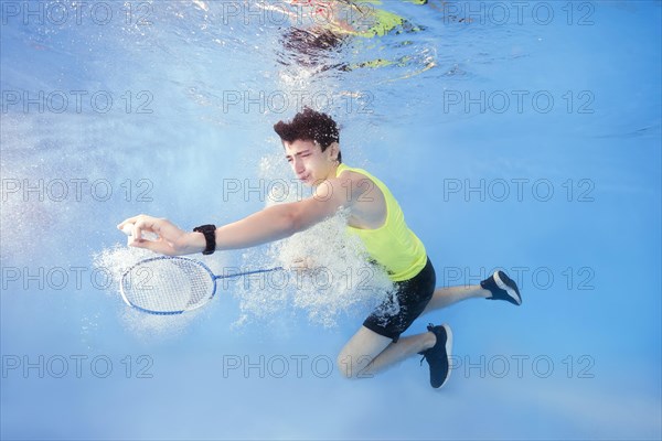 Teen plays badminton underwater