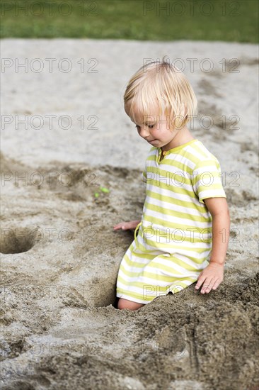 Toddler with 3 years on a playground in the sandbox