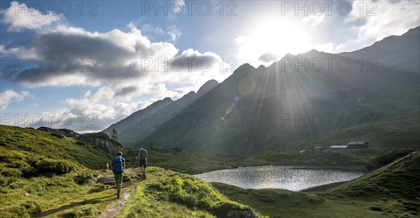 Hikers at the Unterer Giglachsee with morning sun