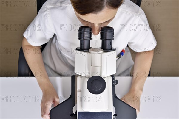 Female scientist using a microscope in a laboratory