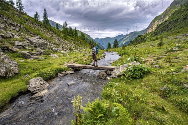 Hiker on a bridge over the Steinriesenbach