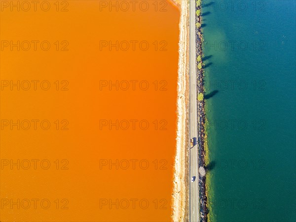 Street trough orange and blue lakes in mining region