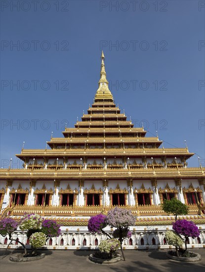 Flowering bushes in front of nine-story stupa Phra Mahathat Kaen Kakhon