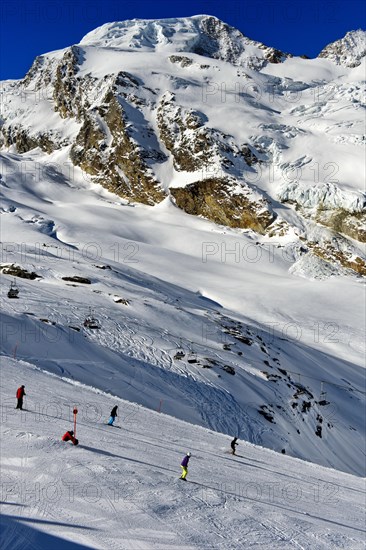 Skiers on the Langfluh ski slope in front of the snow-covered Alphubel