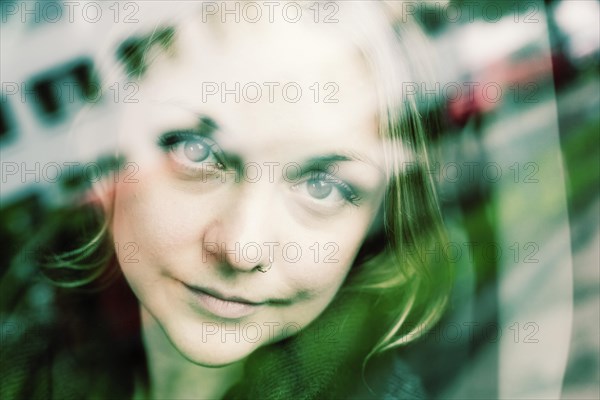 Young woman behind a mirrored glass pane