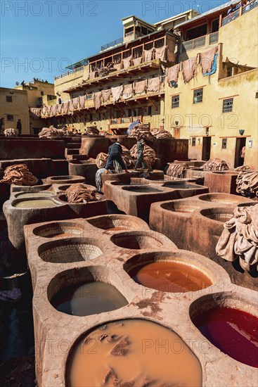 Worker dyeing leather