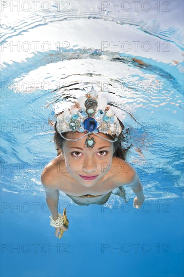 Girl in a mermaid costume poses underwater