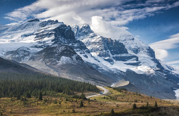 Narrow road with bus in front of spectacular mountain scenery