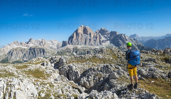 Hiker with climbing helmet on hiking trail to Nuvolau