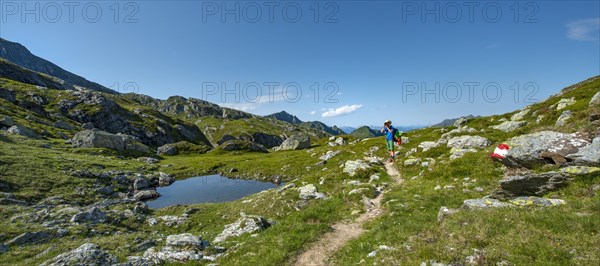 Hiker stehr at a small lake and photographed