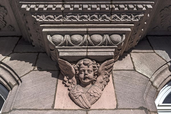Relief of an angel's head under an oriel of a residential house