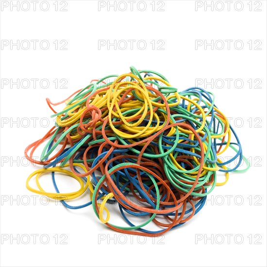 Multicolored elastics on pile on white background