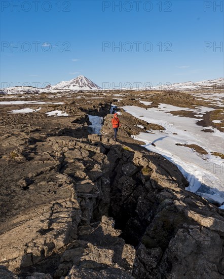 Man stands at Continental Rift between North American and Eurasian Plate