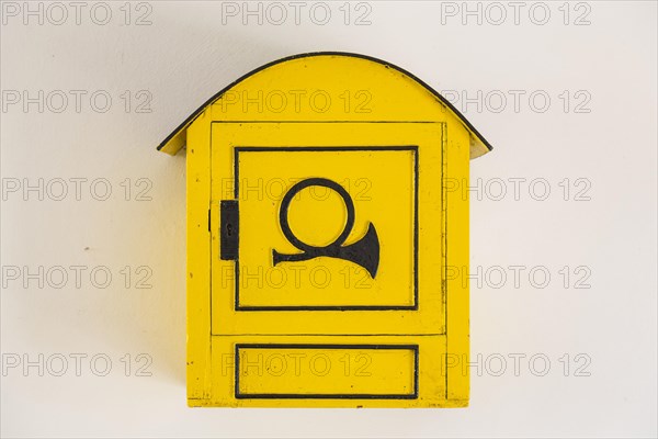 Old yellow mailbox with post horn