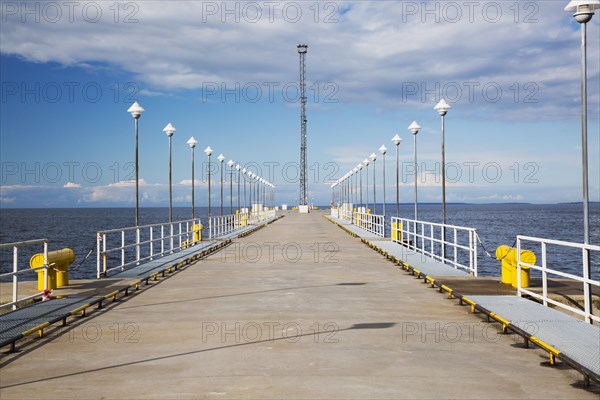 Modern concrete surfaced pier with rows of cone shaped lampposts in port of Tallinn