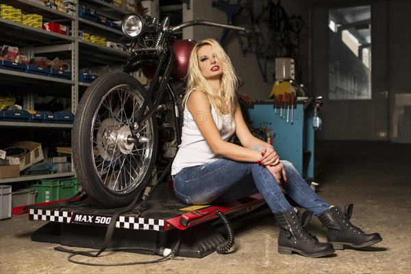 Woman blond poses with motorcycle