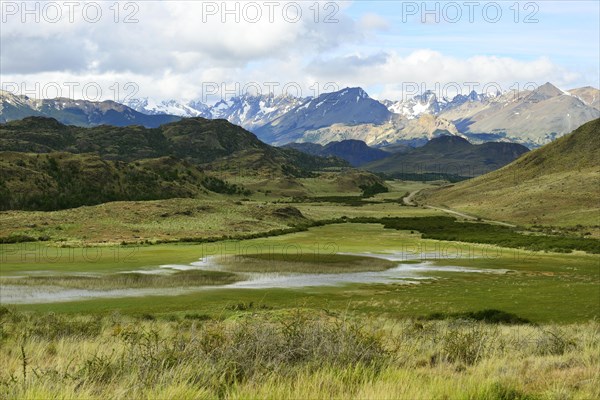 Meandering brook in front of mountain landscape