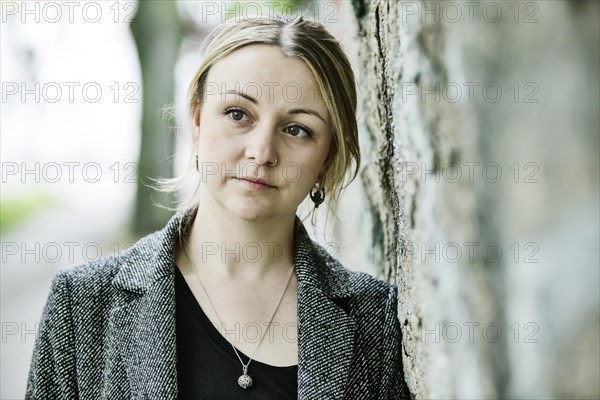 Young woman leaning against a wall