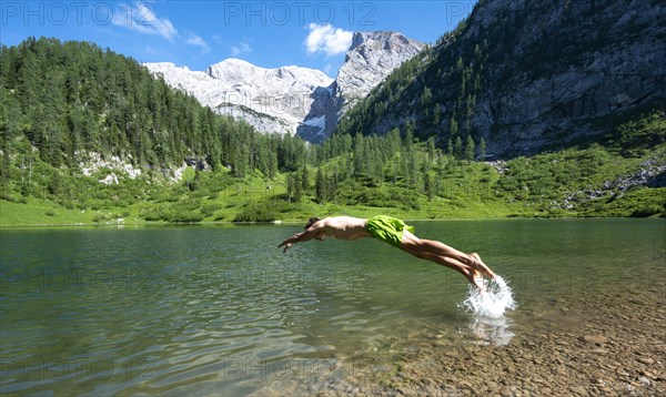 Young man jumps into the water