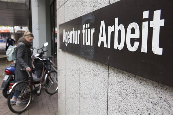 Young woman parks her bicycle in front of the Employment Agency