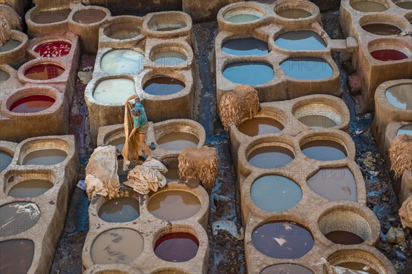 Worker dyeing leather