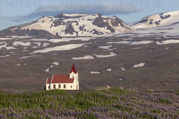 Parish church Ingjaldsholl in front of mountains with snow