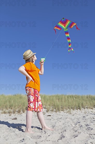 Boy playing with a kite on the beach