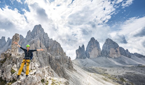 Hiker on the via ferrata to the Paternkofel with summit of the Paternkofel and north faces of the Three Peaks of Lavaredo