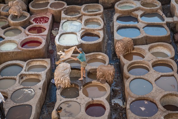 Worker dyeing leather