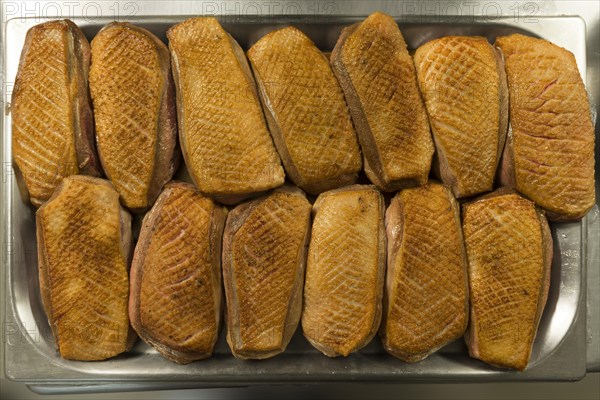 Pre-fried duck breast in a metal bowl