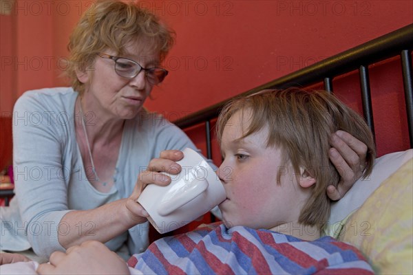 Mother takes care of sick son in bed