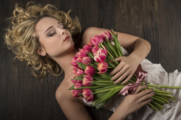 Young woman posing with a bouquet of flowers tulips