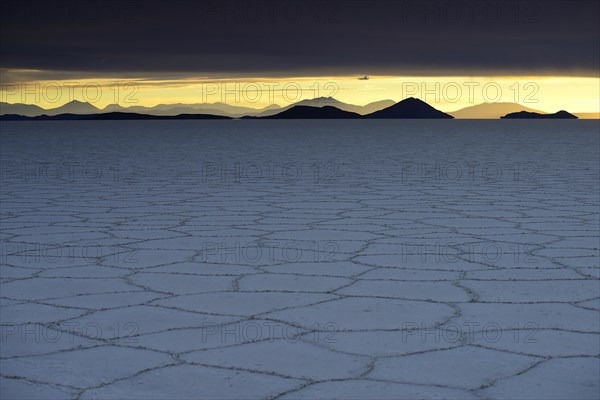 Honeycomb structure on the salt lake at sunset with clouds