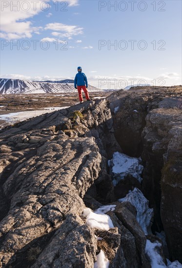 Man stands at Continental Rift between North American and Eurasian Plate