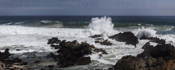 Breaking waves between rocks on the beach