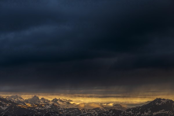 Sunrise over South Tyrolean mountains with dark rain clouds