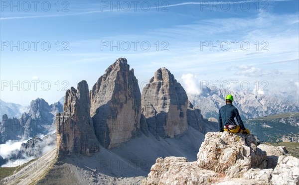 Hiker sits at the summit of the Paternkofel