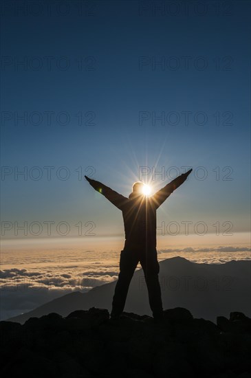 Tourist in backlight waiting for sunset on top of Haleakala National Park