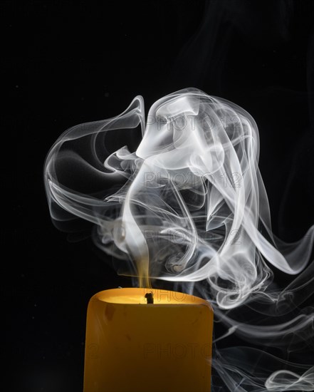 Smoky candle in front of a black background