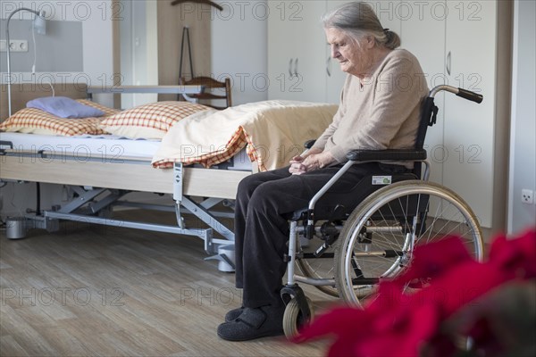 Demented Senior in a wheelchair alone in her room in a nursing home