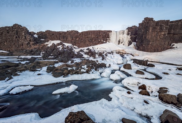 Partially frozen waterfall Oxararfoss in winter