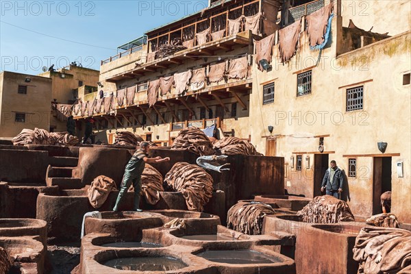 Worker dyeing leather