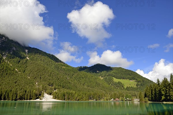 View over the emerald green lake Dobbiaco with mountain forest and Murengang