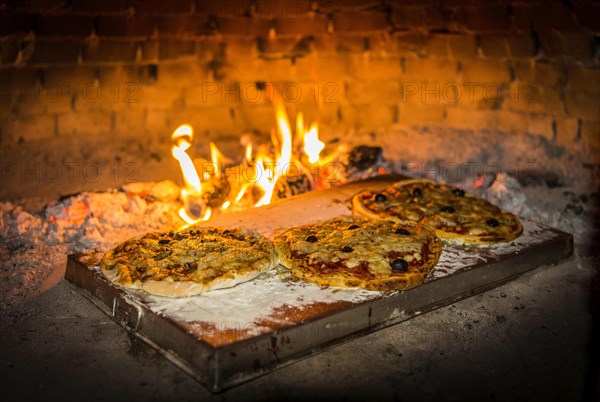 Pizza is baked in a pizza oven