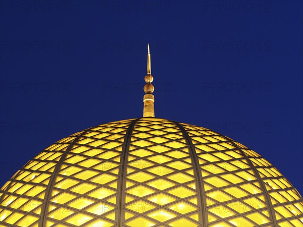 Illuminated dome of the Great Sultan Qabus Mosque at night