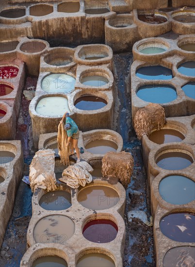 Worker dyeing leather