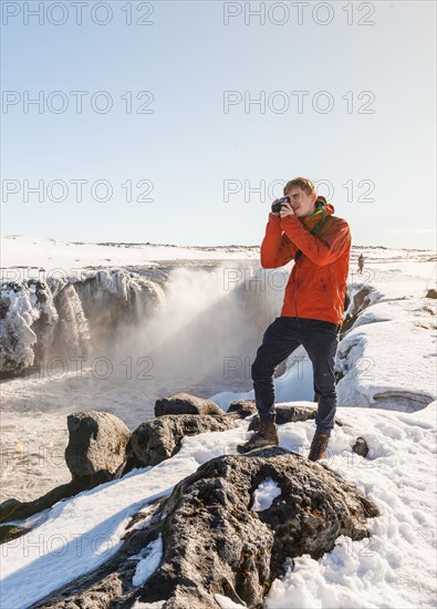 Photographing Man at Selfoss Waterfall in Winter