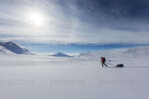 Ski tourer with pulka in the snow