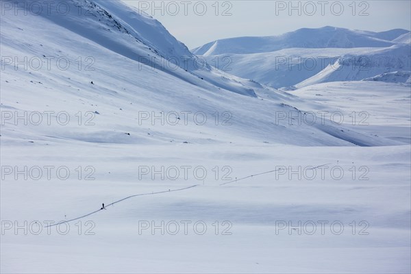 Ski tourer with pulka in the snow