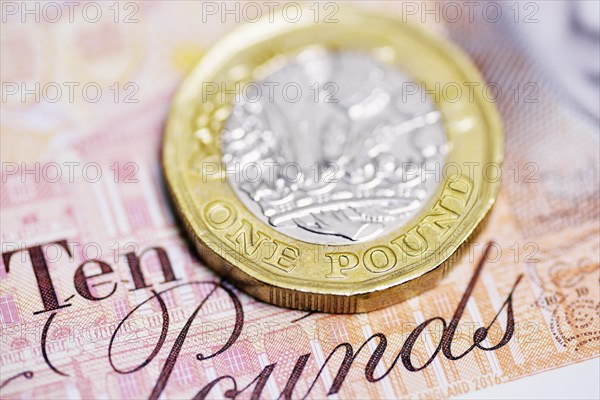 Pound coin on a ten pound note